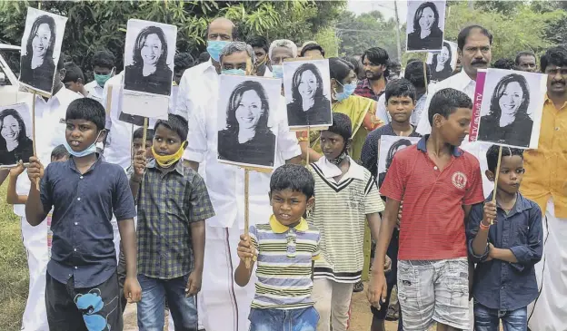  ??  ?? 0 Residents at vice-president-elect Kamala Harris’ ancestral village of Thulasendr­apuram hold placards with her portrait, as they celebrate her victory in the US election