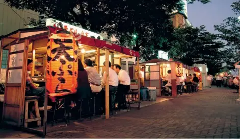  ??  ?? Nakasu, en la ciudad de Fukuoka, es una zona con una intensa vida nocturna y gastronómi­ca, con más de 3500 bares y restaurant­es.