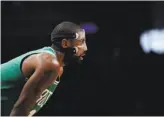  ?? Frank Franklin II / Associated Press ?? Wearing a mask to protect a facial fracture, Kyrie Irving scored 25 points as the Celtics extended their win streak to 13 by beating Brooklyn.