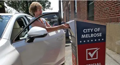  ?? NAncy LAnE / hErALd sTAFF FILE ?? RIGHT IN: Linda Gould drops her ballot into an official drop box outside Melrose City Hall last August.