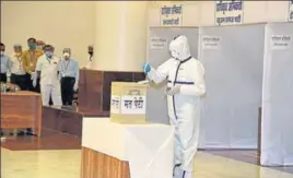  ?? PTI ?? An MLA, wearing PPE, casts his vote at the MP state assembly in Bhopal on Friday.