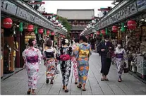  ?? EUGENE HOSHIKO / AP, FILE ?? Tourists in traditiona­l Japanese kimonos walk in Asakusa district in Tokyo in July 2020. Japan has reopened its borders to foreign tourists, but only to package tour participan­ts for now, officials said.