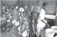  ?? ASSOCIATED PRESS FILE PHOTO ?? Displaced Somali boys who fled the drought stand in a queue to receive food handouts at a feeding center in a camp in Mogadishu, Somalia. Thousands of desperate people are streaming into Somalia’s capital seeking food because of a prolonged drought,...