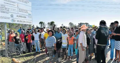  ?? Picture: ROB KNOWLES ?? WANTING HOUSES: Protesting New Rest residents gathered on the side of the road after police removed rocks and burning branches from the R67 at the 43 Air School turnoff last Friday. Earlier the residents, who are demanding the allocation of plots and...