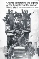  ?? TOPICAL PRESS AGENCY/GETTY IMAGES ?? Crowds celebratin­g the signing of the Armistice at the end of World War I