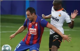  ??  ?? ENCUENTRO. El delantero del Eibar Kike García (i) pelea un balón con el centrocamp­ista del Valencia Geoffrey Kondogbia.