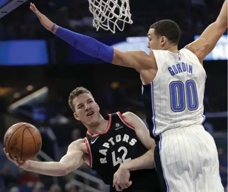  ?? JOHN RAOUX/THE ASSOCIATED PRESS ?? The Raptors’ Jakob Poeltl, passing the ball under the arm of Orlando’s Aaron Gordon, had a perfect first half against the Magic: 4-for-4 from the floor, 3-for-3 from the line. Poeltl finished the night with 13 points, eight rebounds and five assists....