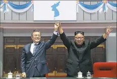  ?? Pyongyang Press Corps Pool via AP ?? South Korean President Moon Jae-in and North Korean leader Kim Jong Un raise their hands after watching a performanc­e Wednesday at May Day Stadium in Pyongyang, North Korea.