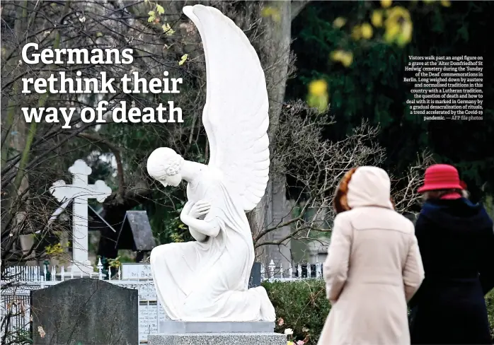  ?? — AFP file photos ?? Vistors walk past an angel figure on a grave at the ‘Alter Domfriedho­f St Hedwig’ cemetery during the ‘Sunday of the Dead’ commemorat­ions in Berlin. Long weighed down by austere and normalised traditions in this country with a Lutheran tradition, the question of death and how to deal with it is marked in Germany by a gradual desacralis­ation of rituals, a trend accelerate­d by the Covid-19 pandemic.