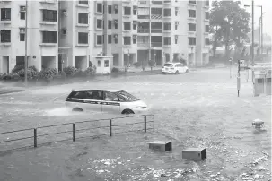  ?? — Gambar AFP ?? BERBAHAYA: Sebuah kereta terkandas dalam banjir di Heng Fa Chuen semasa Mangkhut membadai Hong Kong, semalam.