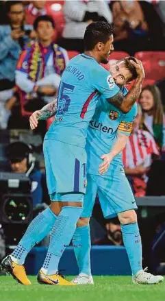  ??  ?? PAULINHO (kiri) dipeluk Messi selepas menjaringk­an gol kedua Barcelona di Stadium San Mames, Bilbao.