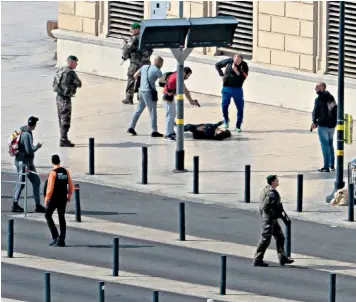  ??  ?? Soldiers and armed security forces stand over the body of a knifeman who killed two young women at Marseille’s main railway station