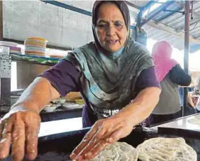  ??  ?? Rasmah menyiapkan roti canai untuk pelanggan.