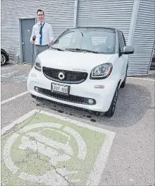  ?? BOB TYMCZYSZYN THE ST. CATHARINES STANDARD ?? Ryan Heikoop with his electric Smart car at the Performanc­e Mercedes dealership.