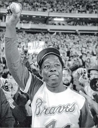  ?? The Associated Press file ?? Hank Aaron holds the ball he hit for career home run No. 715, breaking Babe Ruth’s record, on April 8, 1974, in Atlanta. The Braves’ slugger hit his historic home run off Al Downing at Atlanta-fulton County Stadium.