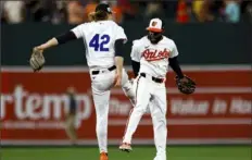  ?? Julia Nikhinson/Associated Press ?? Orioles shortstop Gunnar Henderson, left, and center fielder Cedric Mullins, right, celebrate after a game Monday against the Twins in Baltimore.