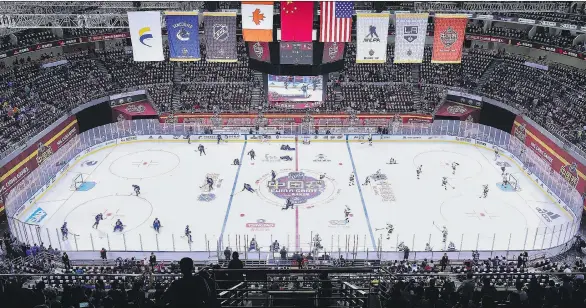  ?? LINTAO ZHANG/GETTY IMAGES ?? The Los Angeles Kings and the Vancouver Canucks go through their pre-game warm-ups for Saturday’s pre-season game at Wukesong Arena in Beijing, China.