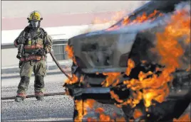  ?? Richard Brian ?? Las Vegas Review-journal @vegasphoto­graph A firefighte­r stands by as car is set on fire during an arson demonstrat­ion and training seminar Friday at the Clark County Fire Academy.