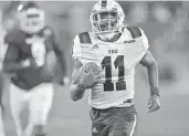  ?? MICHAEL LAUGHLIN/SUN SENTINEL ?? Florida Atlantic quarterbac­k Javion Posey runs past the Florida Internatio­nal defense during the first half on Friday.