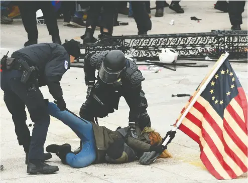  ?? ROBERTO SCHMIDT / AFP via Getty Images ?? Police detain a person as supporters of President Donald Trump protest outside the US Capitol on Wednesday.