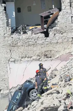  ??  ?? Rescue workers survey the devastatio­n in Pescara del Tronto