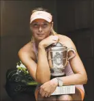  ?? Pool / Getty Images ?? Maria Sharapova poses with the Coupe Suzanne Lenglen trophy after winning the 2014 French Open. Sharapova retired from tennis on Wednesday.