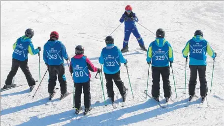  ?? Jeff Kearns For The Times ?? AT NANSHAN Ski Village in north Beijing, students line up for a lesson. “I’m excited and afraid,” said one woman at the faux snow resort.
