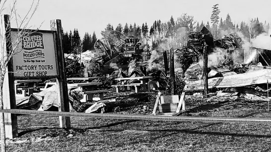  ?? JIM DUMVILLE ?? The sign promoting the plant’s tours and gift shop still stands in front of the smoulderin­g debris Saturday morning.