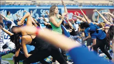  ?? Francine Orr ?? YOGAWORKS PLANS to continue expanding in California, including San Diego and farther into the San Francisco area. Above, YogaWorks teacher Mia Togo leads a class in May at Dodger Stadium after a game.