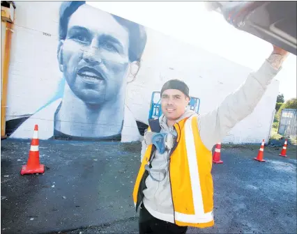  ?? PHOTO / MICHAEL CUNNINGHAM ?? Artist Earnest Bradley with a mural of former All Black Ian Jones, which he painted as part of a beautifica­tion project in Kamo.