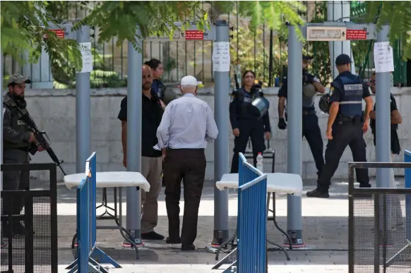  ??  ?? A worshipper passes through metal detectors at Al Aqsa compound. Shin Bet, Israel’s internal security service, has recommende­d they be removed