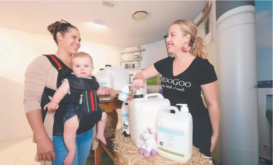  ?? Picture: RICHARD GOSLING ?? Gold Coast skincare company MooGoo will take its refill station idea to Brisbane, Sydney and Melbourne Francesca McCormack with baby Otis McCormack restocks with MoGoo’s Katie Worrell at the second refill day at Burleigh, held yesterday.