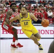  ?? JAY LAPRETE — THE ASSOCIATED PRESS ?? Michigan’s DeVante Jones, right, dribbles up the court as Ohio State’s Jamari Wheeler defends during the first half of an NCAA college basketball game, Sunday, March 6, 2022, in Columbus, Ohio.