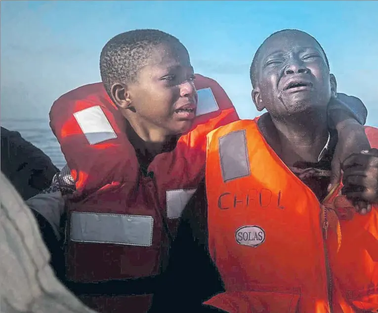  ??  ?? Una niña nigeriana de 11 años y su hermano, de 10, lloran tras ser rescatados por la oenegé catalana Open Arms el pasado julio; contaron que su madre había muerto en Libia