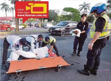  ?? [FOTO MOHD ADAM ARININ/BH] ?? Anggota polis mengangkat mayat Thien Yu selepas dilanggar kenderaan pacuan empat roda untuk dibedah siasat di Hospital Queen Elizabeth.