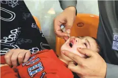  ?? Reuters ?? A boy receives polio vaccine drops from health workers at a booth outside a hospital in Peshawar, Pakistan.