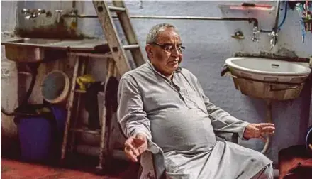  ?? AFP PIX ?? Partition survivor Saleem Hasan Siddiqui at the home in New Delhi where he has lived since the Partition. (Left) Nisar Akhtar and his wife showing prePartiti­on photos at their home in Karachi.