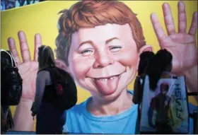  ?? KEVIN SULLIVAN/THE ORANGE COUNTY REGISTER VIA AP, FILE ?? In this July 20, 2017 file photo, the face of Alfred E. Neuman is framed by attendees at the DC booth during the first day of Comic-Con Internatio­nal at the San Diego Convention Center in San Diego, Calif.
