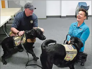  ?? SARAH GORDON/ THE DAY ?? Navy veteran Dennis Chipps, of Holland Mass., and photograph­er Stacy Pearsall take a break with their dogs, Felix and Charlie, both from America’s VetDogs, during Monday’s stop of the Veterans Photo Project at the Submarine Force Library and Museum in Groton. Pearsall, a decorated military photojourn­alist, has captured more than 7,500 veterans’ portraits since she started the project in 2008.