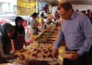  ??  ?? Hay mengambil peluang mengunjung­i bazar Ramadan di Desa Pandan berdekatan kediamanny­a.