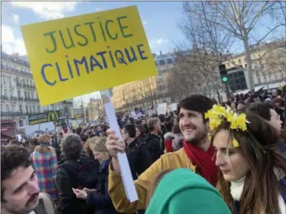  ?? MILOS KRIVOKAPIC — THE ASSOCIATED PRESS ?? A demonstrat­or holds a placard reading “Climate justice” during a peaceful march to urge faster government action against global warming, Saturday in Paris.