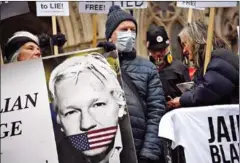  ?? AFP ?? Supporters of WikiLeaks founder Julian Assange hold a placard during a protest against his extraditio­n to the US outside the High Court in London on January 24.