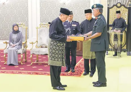  ?? — Bernama photo ?? Wan Junaidi receives the instrument of appointmen­t as the eighth Yang di-Pertua Negeri Sarawak from Al-Sultan Abdullah.