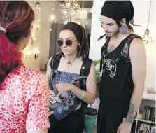  ??  ?? Alicia Muzslai and Josh Atkins speak with a vendor during a cannabis popup market in Ford City on Sunday.