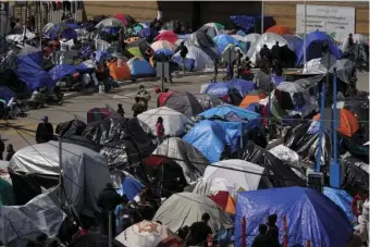  ?? AP PHOTO/GREGORY BULL ?? A makeshift camp of migrants sits at the border port of entry leading to the United States, Wednesday, in Tijuana, Mexico. The migrant camp shows how confusion has undercut the message from U.S. President Joe Biden that it’s not the time to come to the United States. Badly misinforme­d, some 1,500 migrants who set up tents across the border from San Diego harbor false hope that Biden will open entry briefly and without notice.