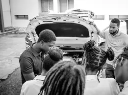  ?? ?? JPS digital analyst Ramon Lewis (left) explains what’s under the hood of an electric vehicle to students taking STEM-based subjects at the UWI CAPE workshops sponsored by the JPS Foundation. Also listening in is JPS Foundation officer Aundhrae Richardson (right).