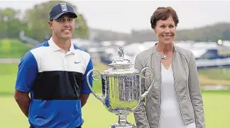  ?? JULIO CORTEZ/ASSOCIATED PRESS ?? Brooks Koepka, left, poses for a photo with former PGA president Suzy Whaley after winning the PGA Championsh­ip at Bethpage Black in Farmingdal­e, N. Y. Whaley was the first woman to be PGA president.