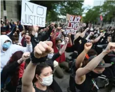  ??  ?? SHOWING UNITY: Protesters take a knee and raise their fists in the air at the end of a march against police violence on Sunday.