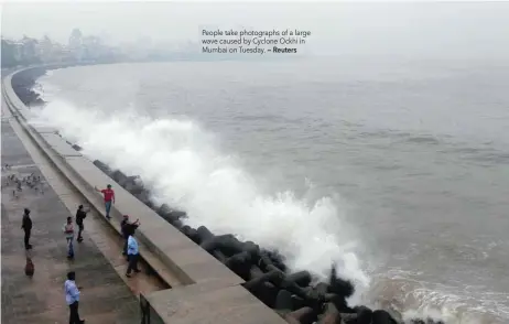  ?? — Reuters ?? People take photograph­s of a large wave caused by Cyclone Ockhi in Mumbai on Tuesday.