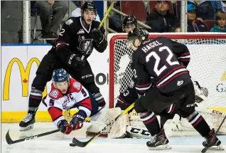  ?? Herald photo by Ian Martens ?? Lethbridge Hurricanes' Tyler Wong dives for the puck between Red Deer Rebels' Brandon Schuldhaus, Brandon Hagel and goaltender Riley Lamb during Game 1 of first-round WHL playoff action Saturday night at the Enmax Centre. @IMartensHe­rald